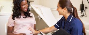 A labor and delivery nurse speaks with her patient