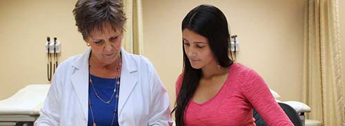 A NURSE PRACTITIONER GOES OVER A MEDICATION LIST WITH A PATIENT